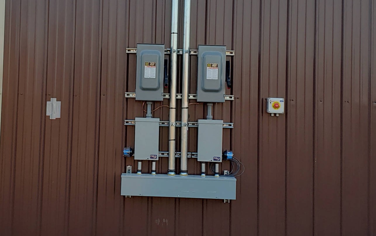 electrical panel setup mounted on the exterior of a metal wall